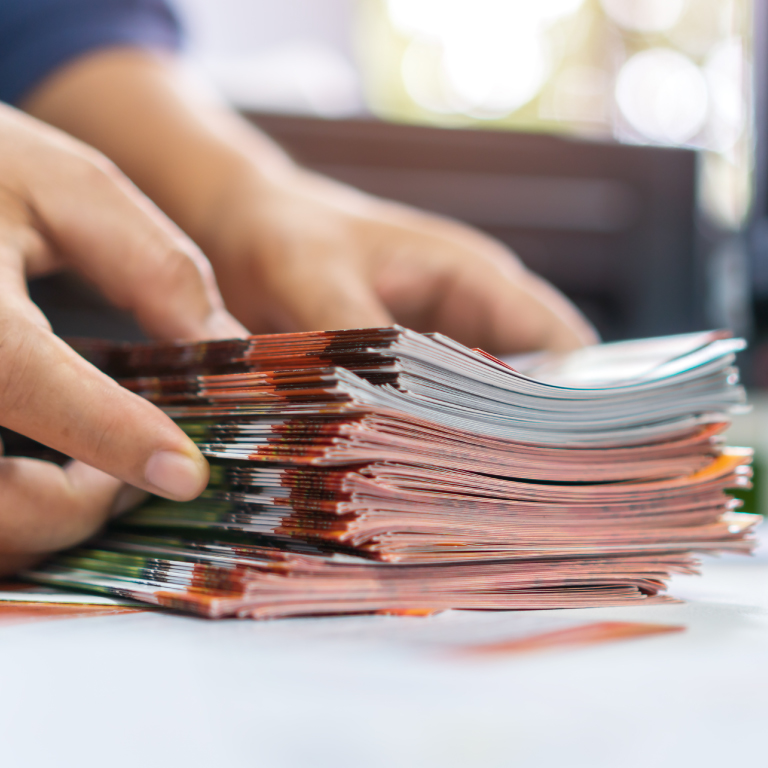 Hands stacking multiple flyers.