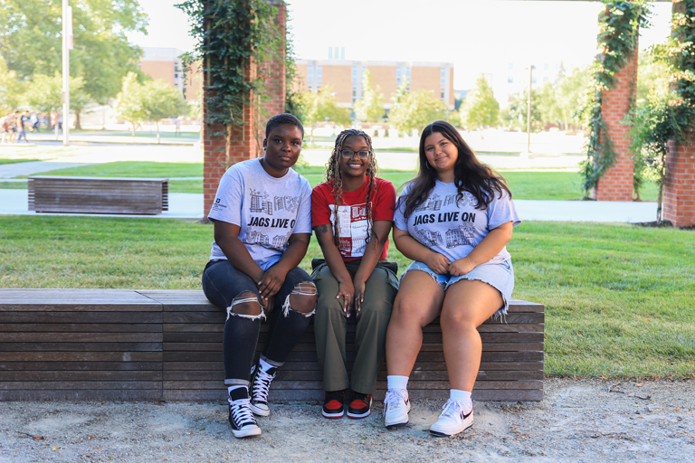 3 RAs sit and smile.